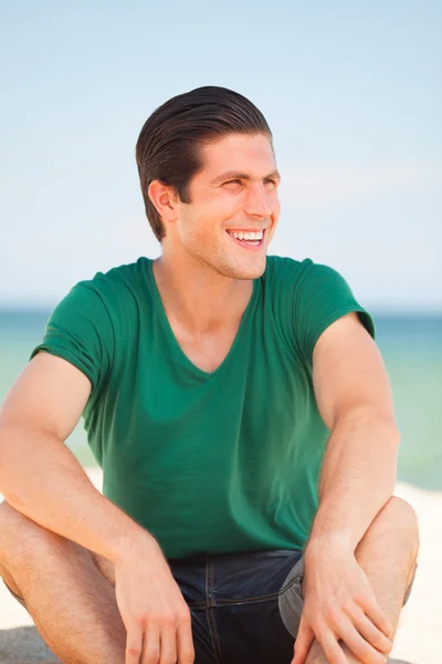 ビーチの背景でハンサムな若い男 — ストック写真