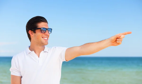 Schöner junger Mann am Strand Hintergrund — Stockfoto