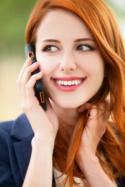 Redhead girl speaking by phone — Stock Photo, Image