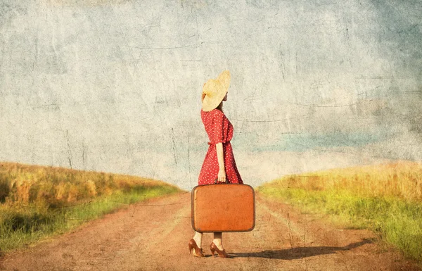 Рыжая девушка с чемоданом на открытом воздухе . — стоковое фото