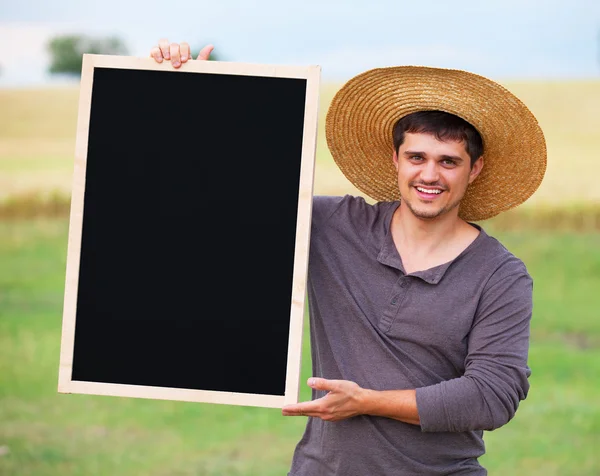 Bauer mit Tafel am Weizenfeld. — Stockfoto