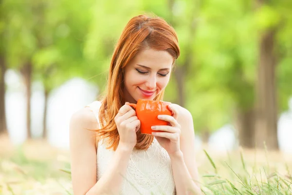 Pelirroja con taza naranja al aire libre — Foto de Stock