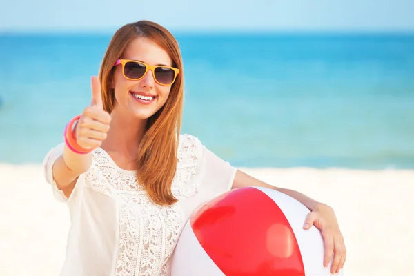 Rotschopf mit Spielzeugball am Strand. — Stockfoto