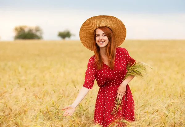 밀 필드에 빨간 드레스에 빨간 머리 소녀 — 스톡 사진