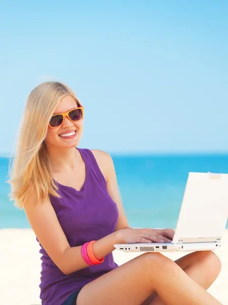 Blond tjej med anteckningsboken på stranden. — Stockfoto