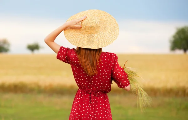 Fille rousse en robe rouge au champ de blé — Photo