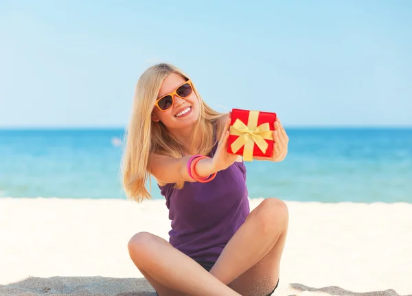 Chica rubia con regalo en la playa . —  Fotos de Stock
