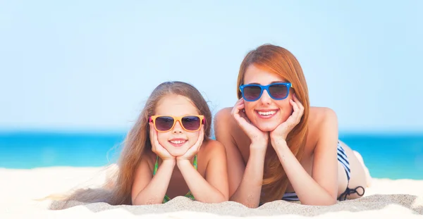 Beautiful mother and little daughter at tropical beach — Stock Photo, Image