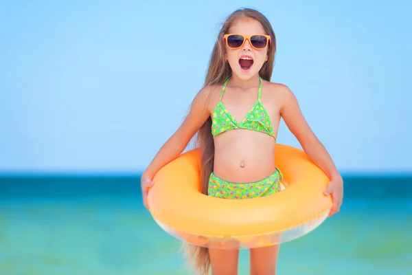 Bambino con occhiali da sole e anello gonfiabile in spiaggia — Foto Stock