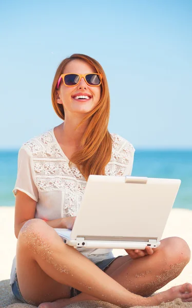 Söt kvinna med vit dator på sommaren stranden — Stockfoto