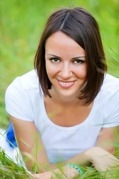 Mooie tiener meisje in het park op groen gras. — Stockfoto