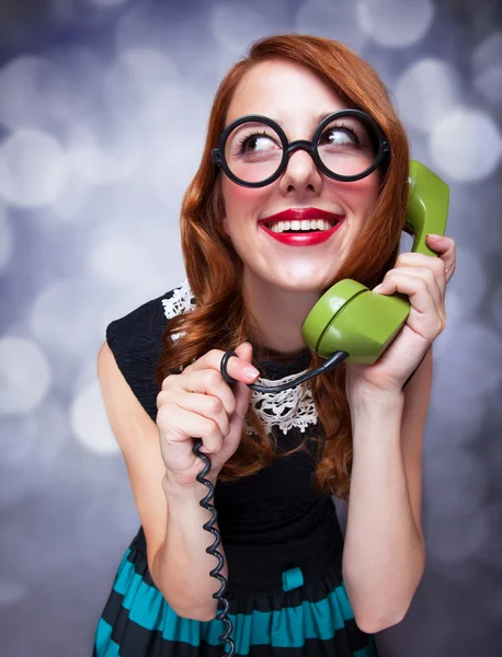 Redhead women with green telephone. — Stock Photo, Image