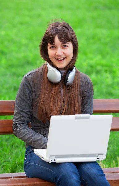 Bruna ragazza seduta alla panchina con notebook — Foto Stock