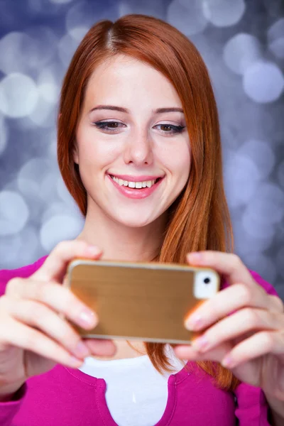 Menina ruiva usando telefone móvel . — Fotografia de Stock