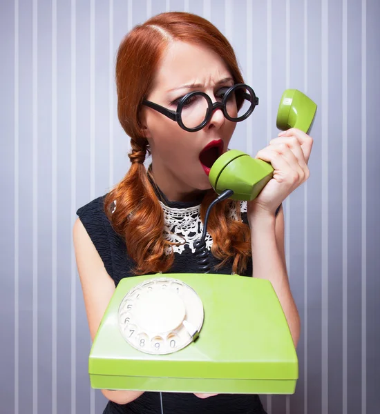 Redhead women with green telephone. — Stock Photo, Image