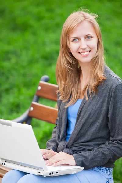 Fille assise sur le banc avec ordinateur portable — Photo