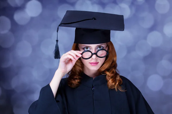 Examen student tjej i en akademisk klänning. — Stockfoto