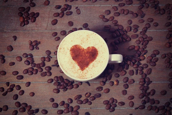 Cup with coffee and shape of the cacao heart on it. — Stock Photo, Image