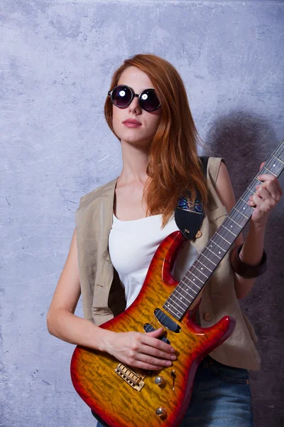 Fille rousse avec guitare près du mur — Photo