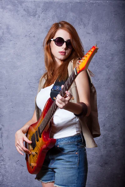 吉他墙附近的红发女孩 — 图库照片