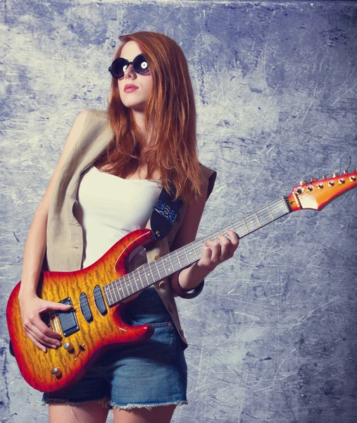 Fille rousse avec guitare près du mur — Photo