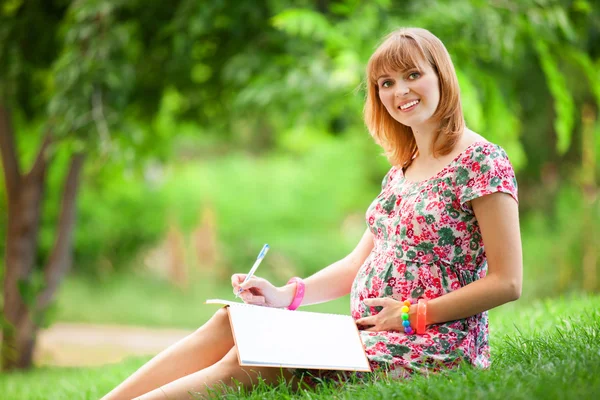 Young beautiful pregnant woman in the park — Stock Photo, Image
