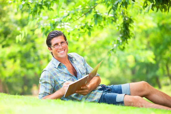 Joven estudiante con nota al aire libre — Foto de Stock