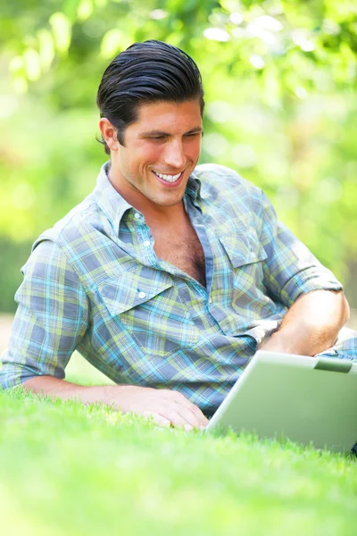 Studerande med bärbar dator vid grönt gräs — Stockfoto