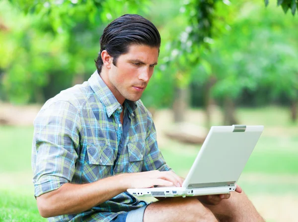 Studerande med bärbar dator vid grönt gräs — Stockfoto