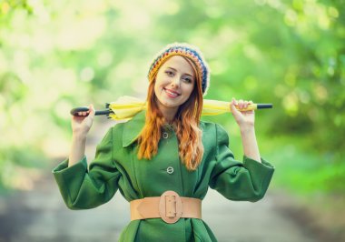 Kızıl saçlı kız, açık şemsiye ile