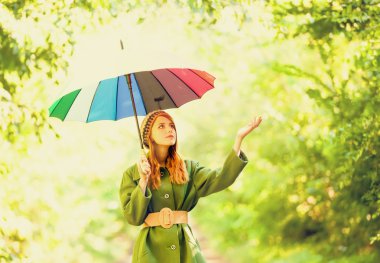 Kızıl saçlı kız, açık şemsiye ile