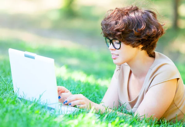 Brunette meisje met laptop buiten. — Stockfoto