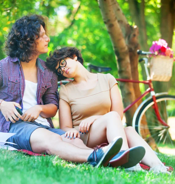 Couple with retro bike in the park — Stock Photo, Image