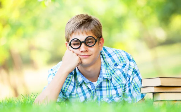 Tiener jongen met boeken in het park. — Stockfoto