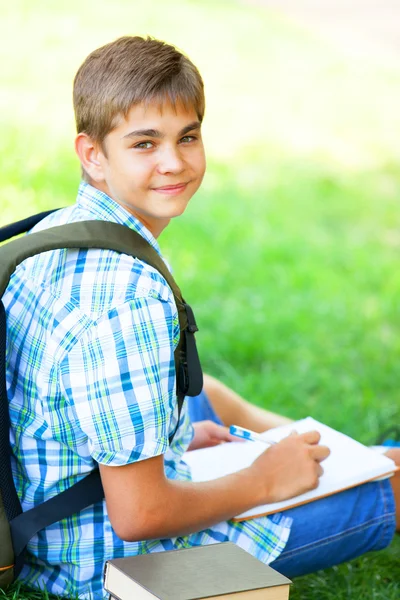 Niño adolescente con libros y cuaderno al aire libre . — Foto de Stock