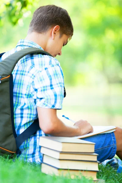 Teen boy with books and notebook at outdoor. — Stock Photo, Image