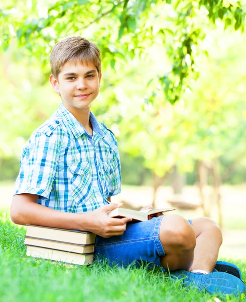 Tini fiú könyvek és a notebook a parkban. — Stock Fotó