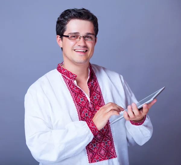 Muž v košili výšivky s tabletem — Stock fotografie