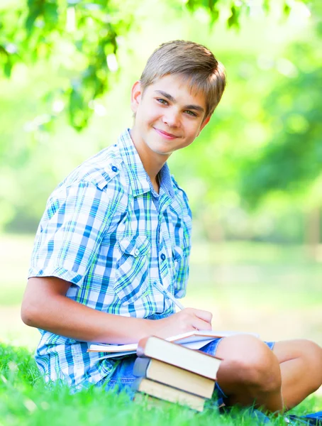 Teen boy con libri e quaderno nel parco . — Foto Stock