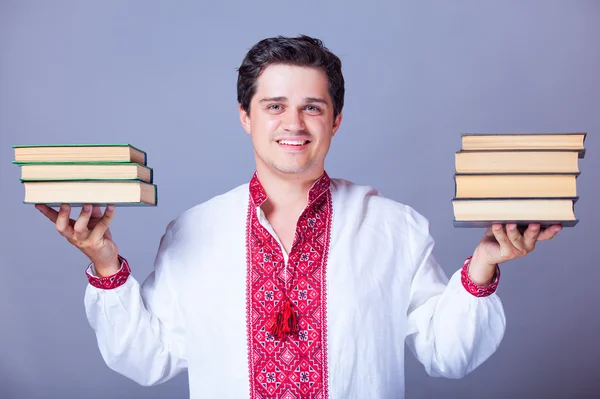 Mannen i broderi skjorta med böcker. — Stockfoto