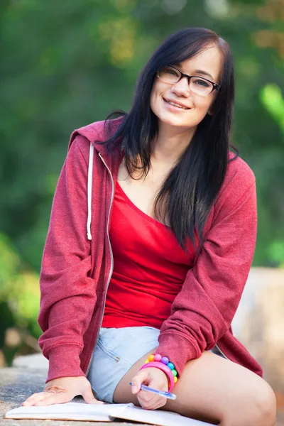 Tiener meisje met laptop in het park. — Stockfoto