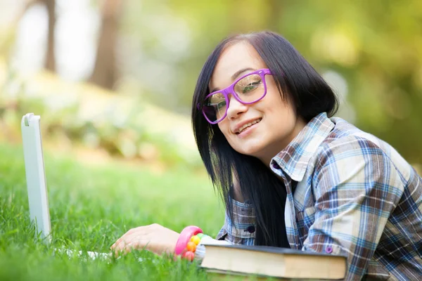 Teen flicka med laptop i parken. — Stockfoto