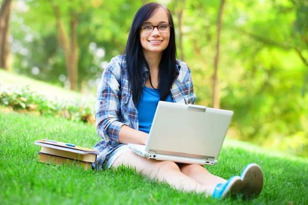 Tiener meisje met laptop in het park. — Stockfoto