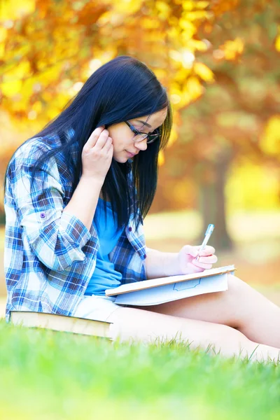 Tiener meisje met laptop in het park. — Stockfoto