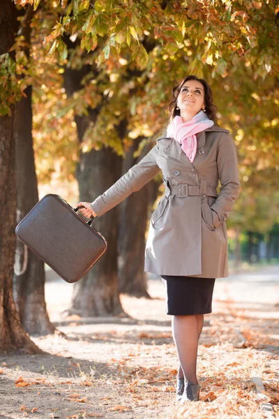 Девушка с чемоданом на осеннем открытом воздухе — стоковое фото