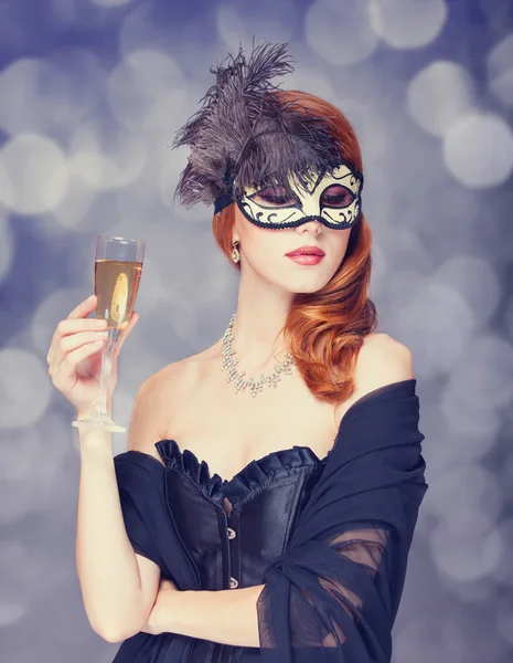 Rödhåriga kvinnor i mask med champagne — Stockfoto