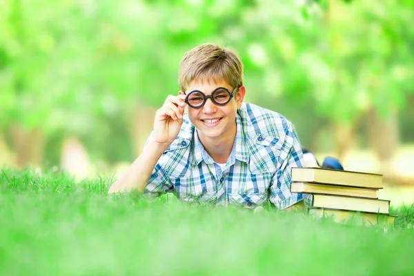 Teen pojke med böcker i parken. — Stockfoto