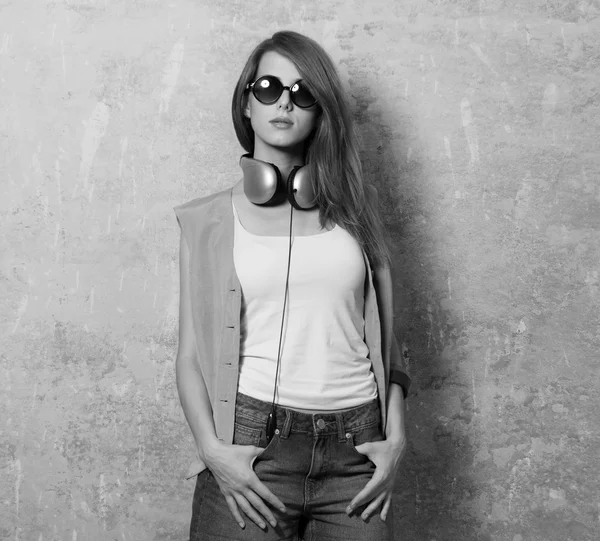 Grunge girl with headphones near wall — Stock Photo, Image