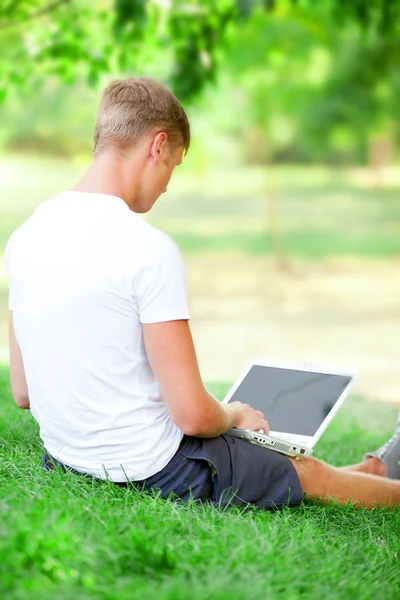 Teen chłopiec z laptopa w parku. — Zdjęcie stockowe