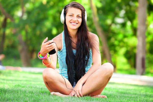 Brunette meisje met koptelefoon op buiten — Stockfoto